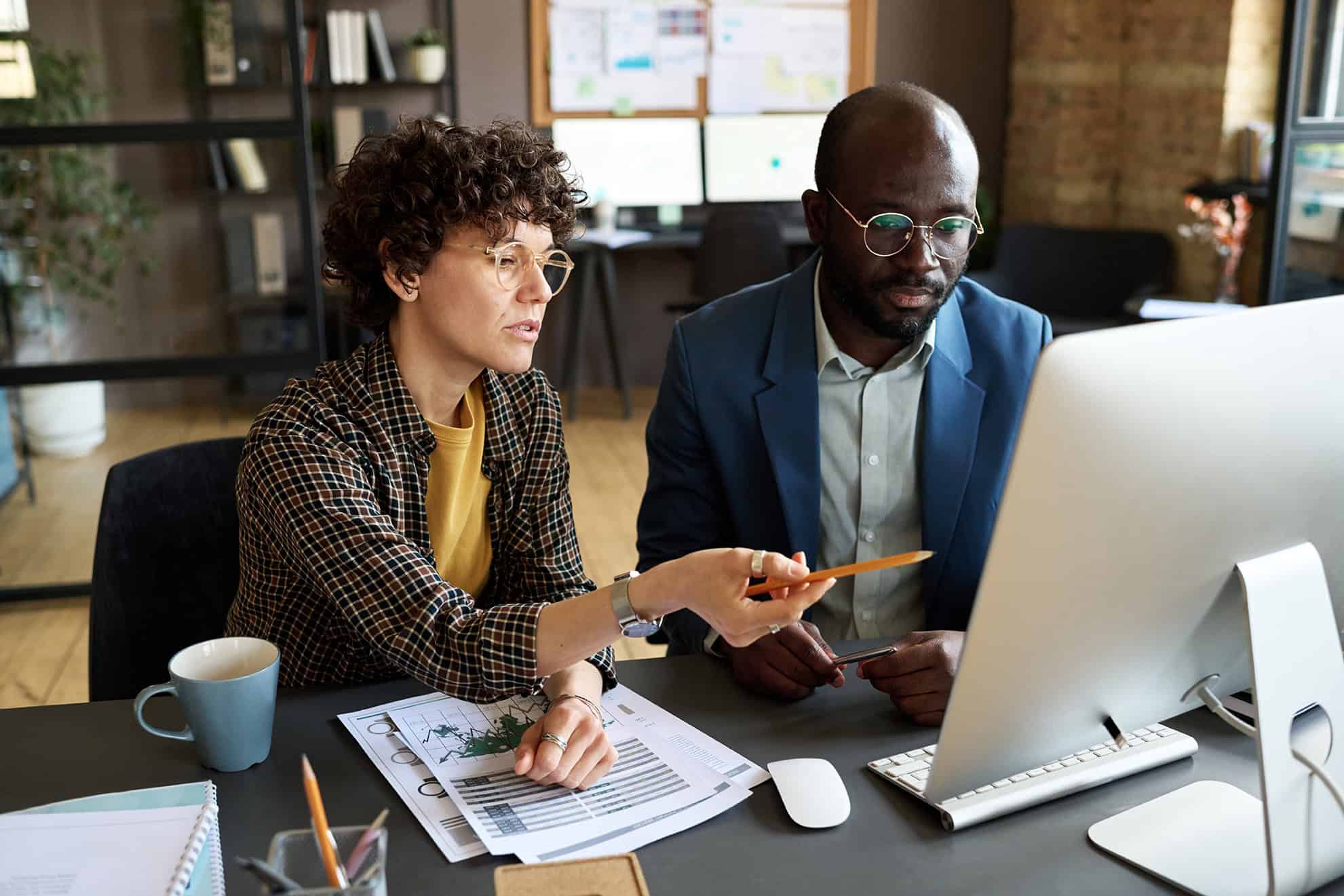 Business people discussing presentation on computer